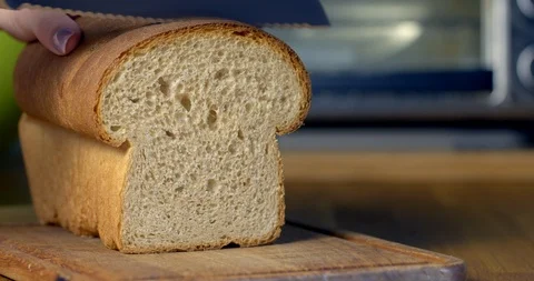 Cutting slice of homemade bread in front of toaster 4K Stock Footage 86375704