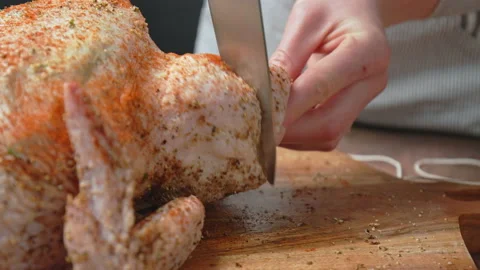 Cutting a slice on a raw chicken drumstick for better marinade before grilling. Stock Footage 145109577