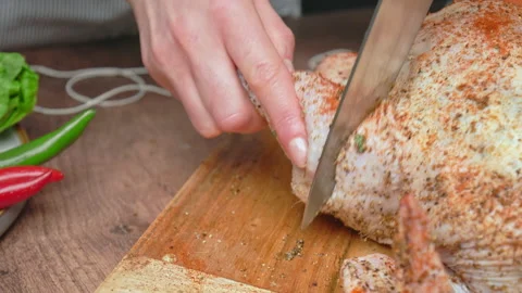 Cutting a slice on a raw chicken drumstick for better marinade before grilling. Stock Footage 145110154
