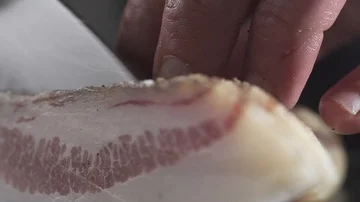 Cutting a Slice of Roman Bacon Stock Footage 85884740
