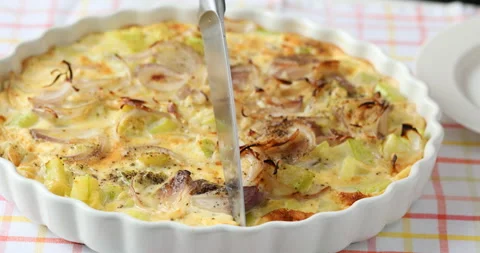 Cutting a slice of summer squash and onion omelet 스톡 동영상 136418611