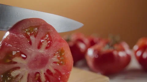 CUTTING A SLICE OF TOMATO - MUSTARD BACKGROUND Stock Footage 132778678