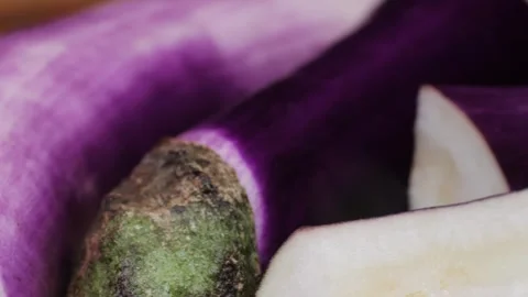 Cutting slice of a violet eggplant is placed on a wooden cutting board Stock Footage 274745739
