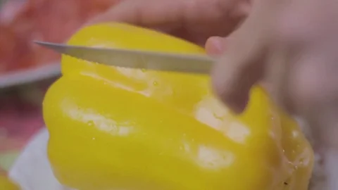 Cutting slice of a yellow bell pepper and removing the seeds Stock Footage 75612433