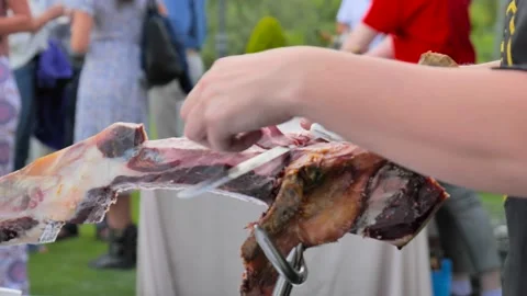 Cutting slices of iberian ham in an elegant outdoor cocktail Stock Footage 205400529