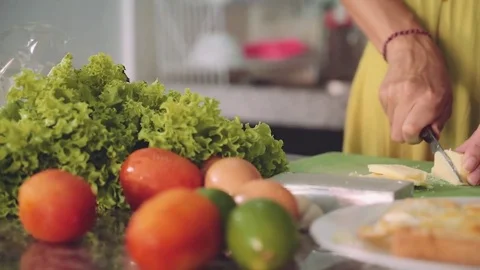 Cutting soft cheese for sandwich on a kitchen table, woman hands Stock Footage 77901292