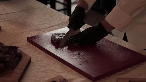 Cutting steak meat in restaurant kitchen by chef person  Stock Footage 132135913