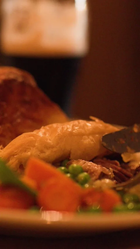 Cutting Into Steak Pie with Vegetables in Cozy Restaurant Stock Footage 317538436