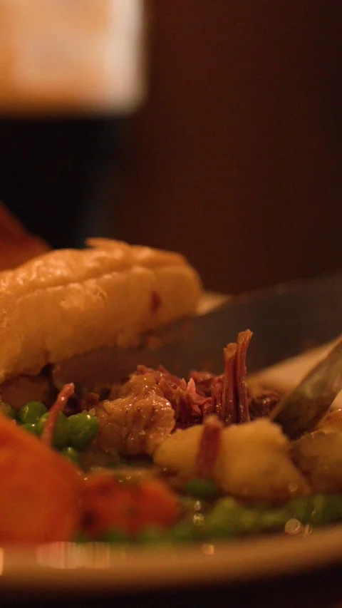 Cutting Into Steak Pie with Vegetables in Cozy Restaurant Stock Footage 317591383