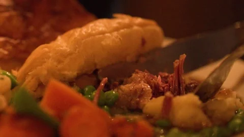 Cutting Into Steak Pie with Vegetables in Cozy Restaurant Stock Footage 319742701