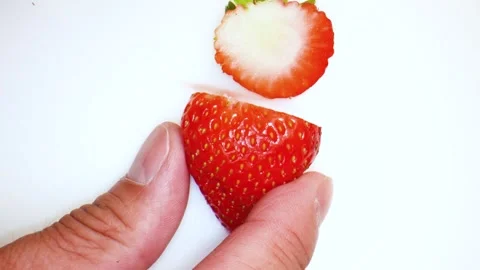 Cutting strawberries on white background  Stock Footage 284999794