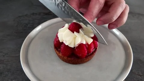 Cutting strawberry tartlet in half Stock Footage 345340437