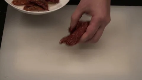 Cutting sun-dried tomatoes and tearing turkey above view Stock Footage 113528253