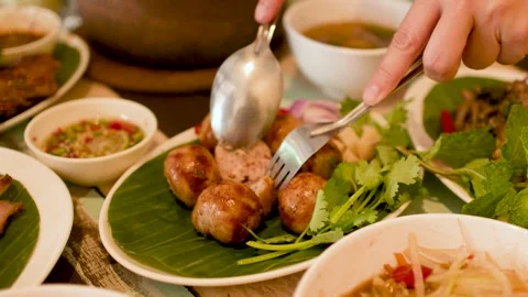 Cutting Thai Isan Fermented Sausages with Spoon and Fork 스톡 동영상 344089644
