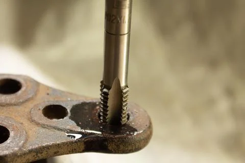 Cutting a thread in a hole with a tap by hand. Material high speed steel. We  Stock Photos