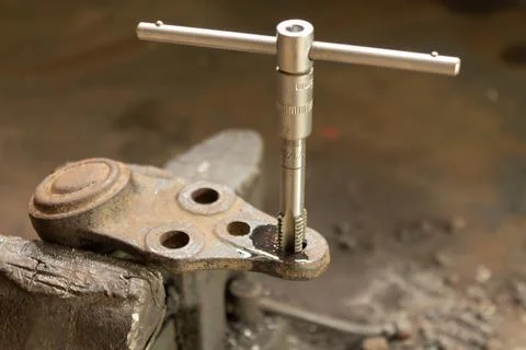 Cutting a thread in a hole with a tap by hand. Material high speed steel. We  Stock Photos