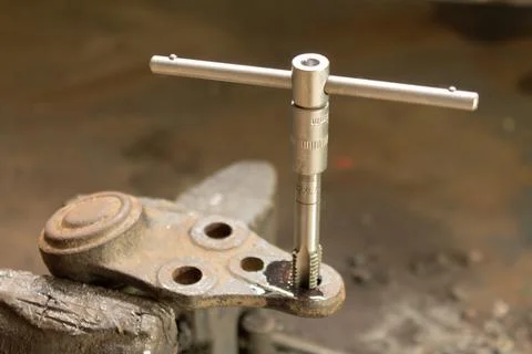Cutting a thread in a hole with a tap by hand. Material high speed steel. We  Stock Photos