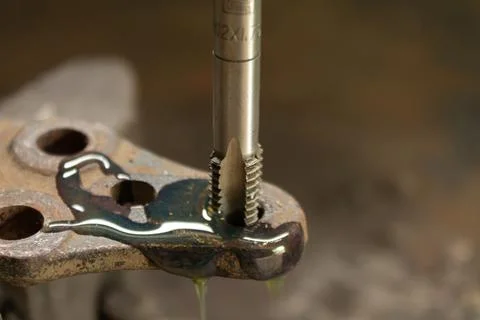 Cutting a thread in a hole with a tap by hand. Material high speed steel. We  Stock Photos