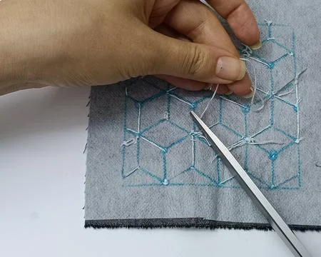 Cutting thread while stitching geometric sashiko embroidery on fabric Stock Photos