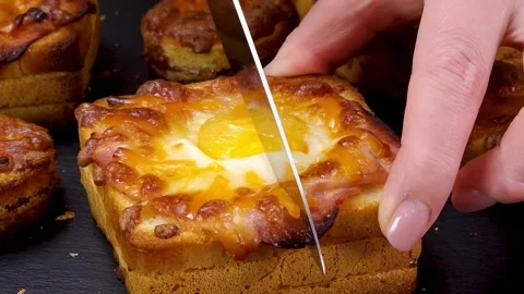 Cutting through a freshly baked egg and ham sandwich with melted mozzarella chee Stock Footage 324943340