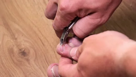 Cutting toenails. man doing a pedicure on his feet Stock Footage 156814906