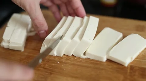Cutting tofu with knife on a cutting board Stock Footage