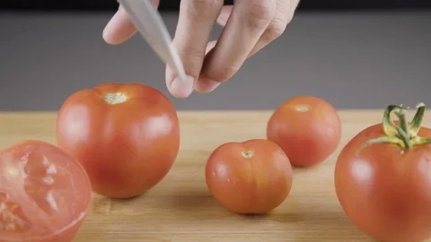 Cutting tomato with big kitchen knife Stockbeeldmateriaal 94030698