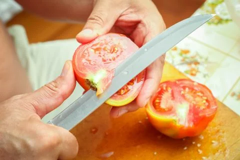 Cutting tomato on board Stock Photos