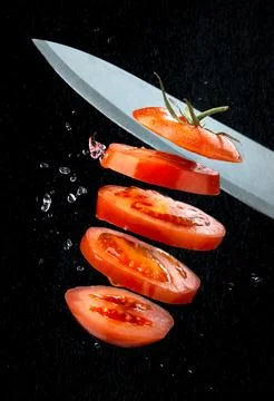 Cutting tomato on the fly Stock Photos