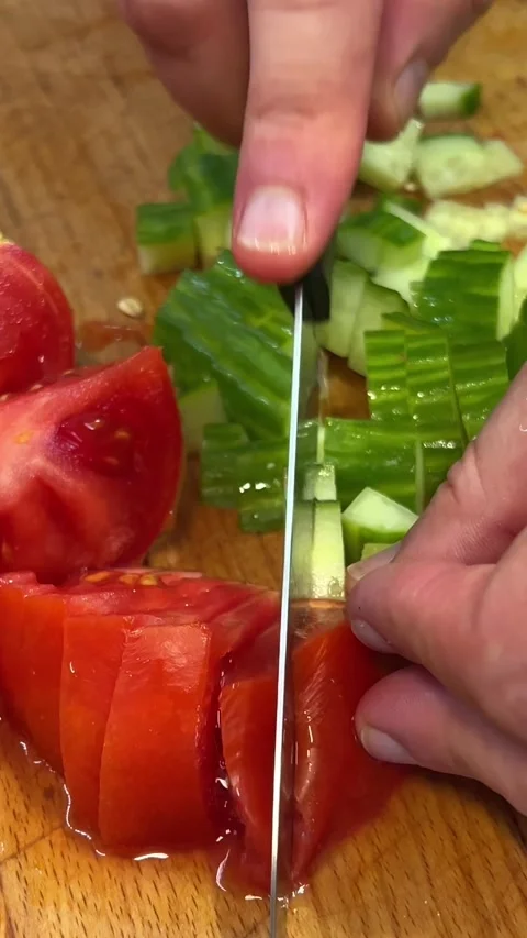 Cutting Tomato Slice with Sharp Knife on the Wooden Chopping Board and Splashing Stock Footage 274482908