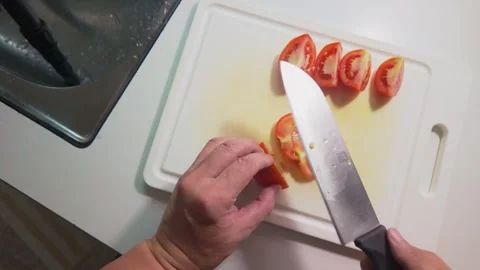 Cutting a Tomato into Slices, Halves and Small Diced Pieces Stock Footage 346304697