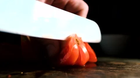 Cutting tomato with white ceramic knife on a rustic wooden board Stock Footage 140369999
