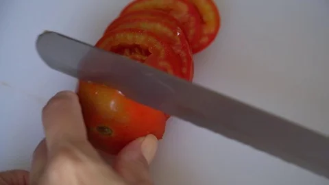 Cutting a tomato by a woman's hand Stock Footage 80066326