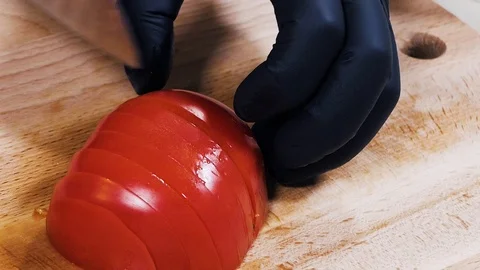 Cutting tomatoes on a cutting board. Close-up. Slow motion. Focus in. Female 動画素材 126488855