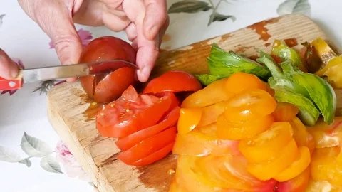 Cutting tomatoes in a kitchen. Stock Footage 94970215