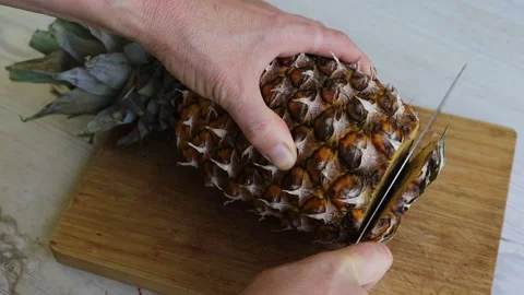 Cutting off the top and the bottom of fresh pineapple on a wooden cutting b.. Stock-Footage 280324850