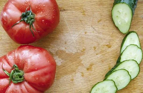 Cutting vegetables for salad. Stock Photos