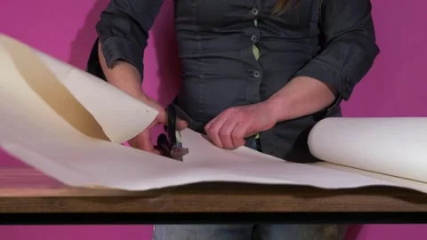 Cutting wallpaper on a table with scissors Stock Footage 163285798