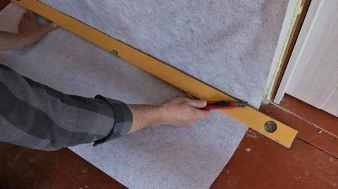 Cutting wallpaper on the wall by level Stock Photos