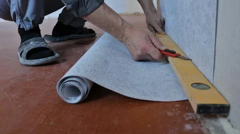 Cutting wallpaper on the wall by level Stock Photos