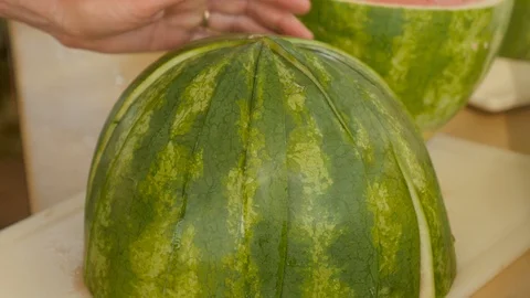 Cutting watermelon into large strips on cutting board Stock Footage 94219268