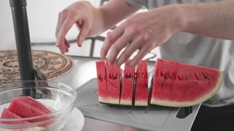 Cutting watermelon into pieces in a kitchen with simple tools and hands wor.. Stock Footage 340193657