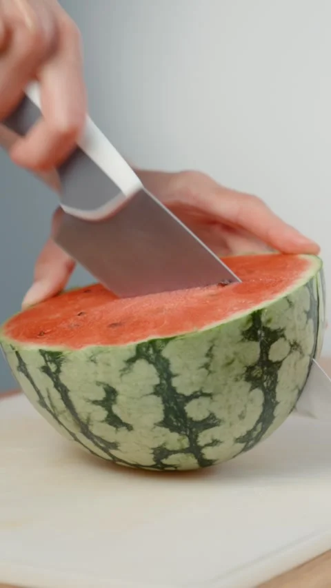 Cutting Watermelon into Quarters with Kitchen Knife Close up Stock Footage 343938557