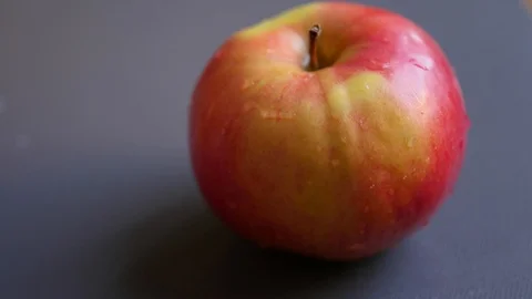 Cutting wet red apple on two parts Stock Footage 88771273