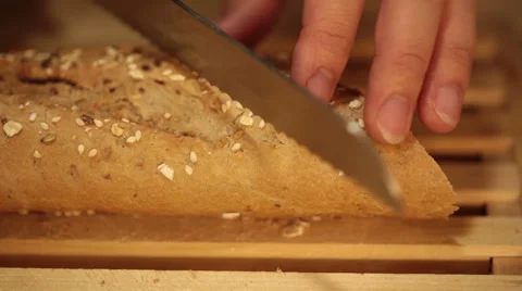 Cutting whole wheat bread baguette into small pieces Stock Footage 68455016