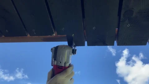 Cutting Wood with Power Tool Beneath Blue Sky Stockbeeldmateriaal 343865445