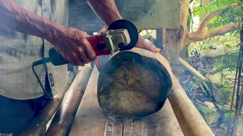 Cutting a Wooden Log with an Angle Grinder in a Rustic Workshop Stock Footage 329401608