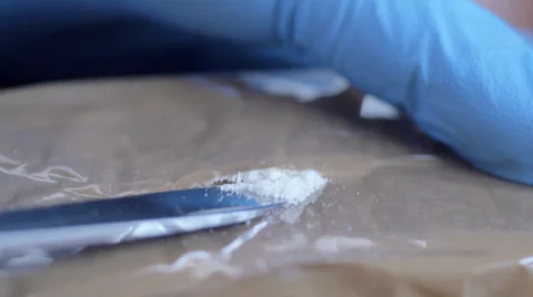 Cutting into wrapped block of narcotics Stock Footage 36479126