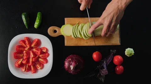 Cutting Zucchini on Black Table. Fast Motion Cooking Preparation with Fresh Stock Footage 315428946