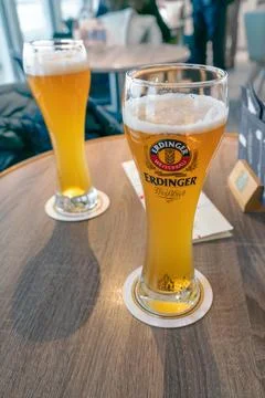 Cuxhaven, Germany - 02.25.2022: Two slim tall glasses o Erdinger Weissbier on a Stock Photos
